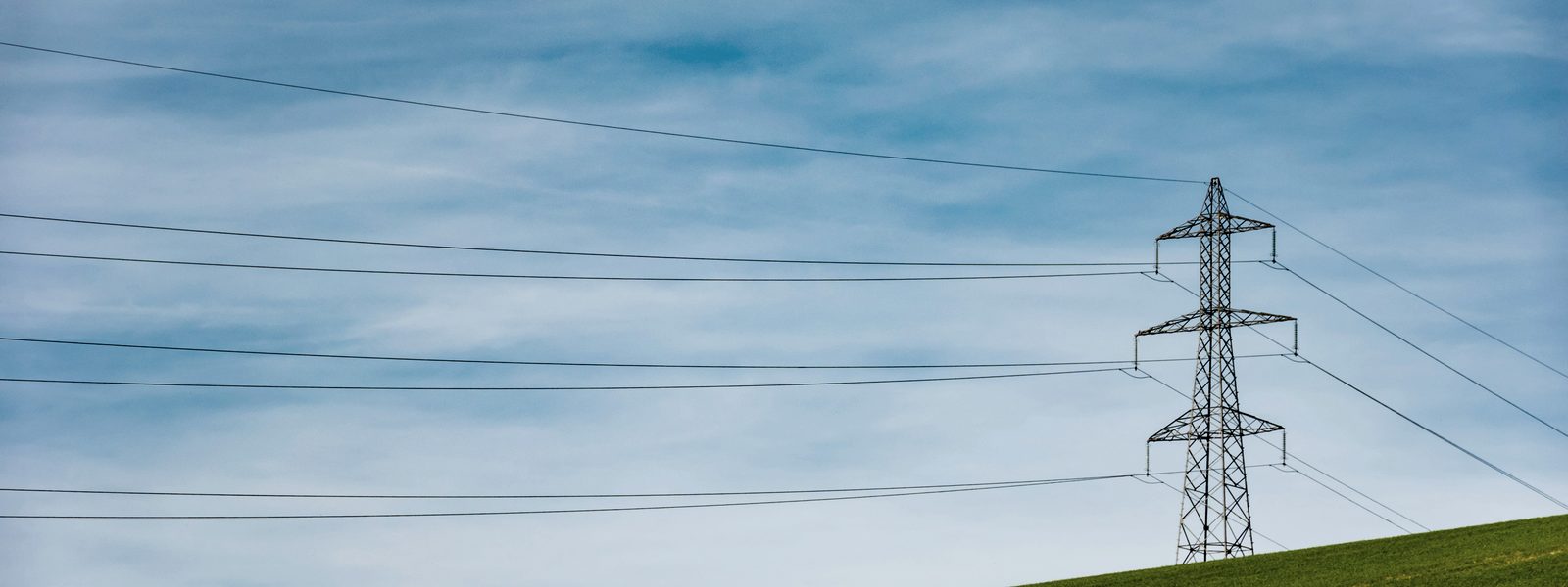 High-voltage transmission lines crossing open countryside